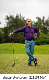 Golfer Leaning On His Golf Club On The Green Low Angle