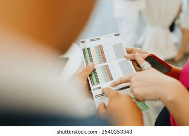 A golfer marks a score on a golf scorecard - Powered by Shutterstock