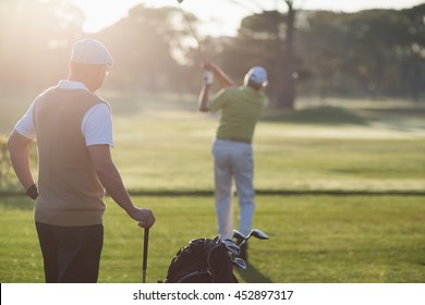 Golfer men standing on field during sunny day