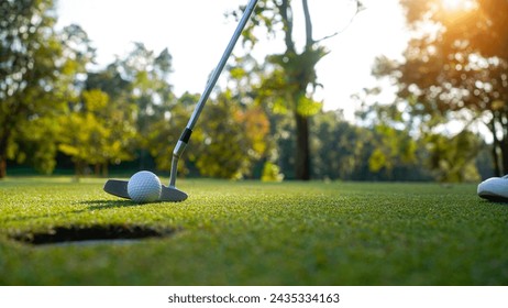 Golfer playing golf in the evening golf course, on sun set evening time. Man playing golf on a golf course in the sun.                                - Powered by Shutterstock