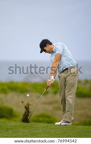 Golfer plays an iron shot from the fairway