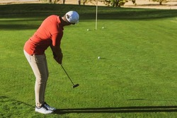 Golfer Practicing Putter Technique, Alignment, Grip And Stance On The Putting Green At The Golf Driving Range. Golf Practices. Golf Putter Stroke To The Hole. Golfer Hitting Training Putt In The Hole