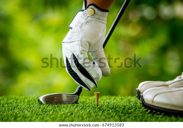 golfer preparing golf
ball for teeing off