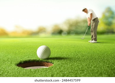 Golfer putting golf ball to the hole on green golf. - Powered by Shutterstock