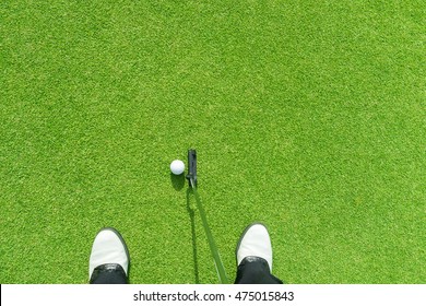 Golfer putting golf ball on the green golf. golfer eye view. copy space upper side.