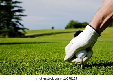 Ein Golfer baut einen Tee auf einem Driving Range auf