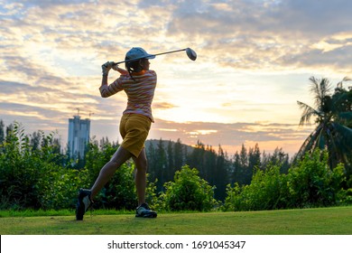 Golfer sport course golf ball fairway.  People lifestyle woman playing game golf tee of on the green grass sunset background.  Asia female player game shot in summer.  Healthy and Sport outdoor