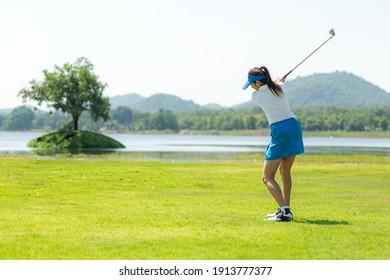 Golfer sport course golf ball fairway. People lifestyle woman playing game golf and hitting go on green grass river and mountain background.  Asia female player game shot in summer.  Healthy  Sport - Powered by Shutterstock