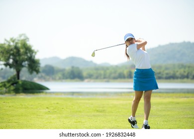 Golfer-Sportplatz Golfplatz Golf Fairway. Menschen Lifestyle Frau spielen Golf und treffen auf grünem Gras Fluss und Berg Hintergrund.  Asiatische Spielerinnen im Sommer.  Gesunder Sport