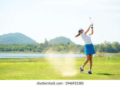 Golfer sport course golf ball fairway. People lifestyle woman playing game golf and hitting out of sand trap go on green grass.  Asian female player game shot in summer.  Healthy and Sport outdoor - Powered by Shutterstock
