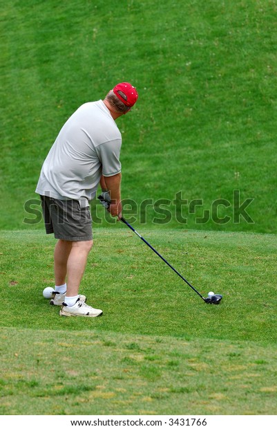 Golfer teeing off at the\
golf course.