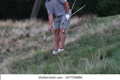 A Golfer Tries To Figure Out Which Club To Use From A Bad Lie