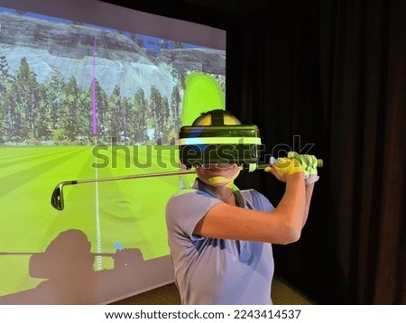 Golfer in virtual glasses plays golf closeup. Golf game indoor simulator