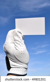 Golfer Wearing Golf Glove Holding A Blank Business Card Against A Blue Sky