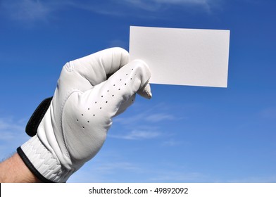 Golfer Wearing Golf Glove Holding A Blank Business Card Against A Blue Sky