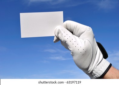 Golfer Wearing Golf Glove Holding A Blank Business Card Against A Blue Sky