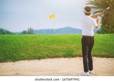 Golfers exploding sand in the bunker. View from behind.  Concept of Outdoor activities and Outdoor sports, Concept of Golfer and Lifestyle. 