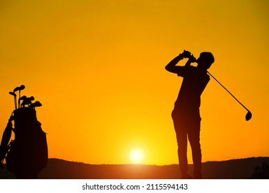 Golfers' hit golf ball toward the hole at sunset silhouetted. Golden morning sky in winter, misty high mountain background.                                - Powered by Shutterstock