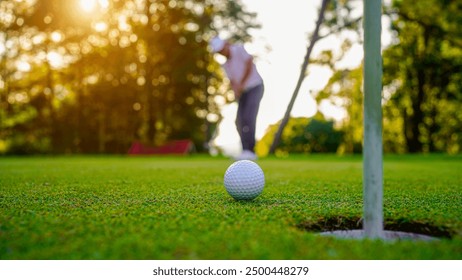 Golfers are putting golf in the evening golf course golf backglound. Golfer hitting golf ball. Sport holiday lifestyle Concept.                                - Powered by Shutterstock