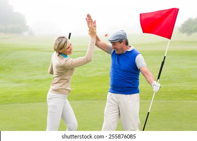 Golfing Couple High Fiving On The Golf Course On A Foggy Day At The Golf Course