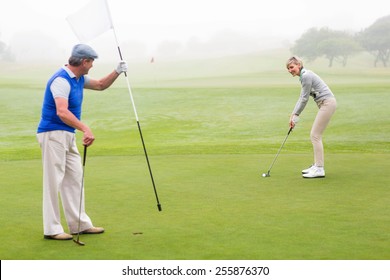 Golfing Couple On The Golf Course On A Foggy Day