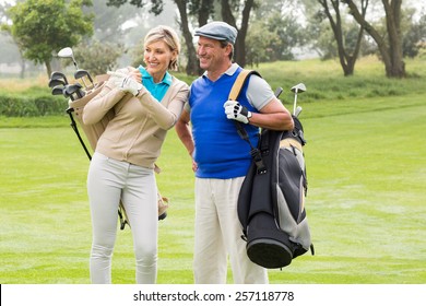 Golfing Couple Walking On The Putting Green On A Foggy Day At The Golf Course