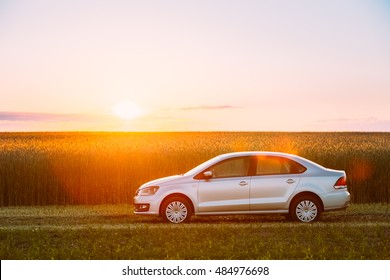 Gomel, Belarus - June 6, 2016: Volkswagen Polo Car Parking On Wheat Field. Sunset Sunrise Dramatic Sky On A Background In Sunny Evening.