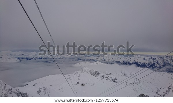 Gondola lift cable at top of Mont Fort in\
Verbier on a cloudy Winter day - Swiss\
Alps