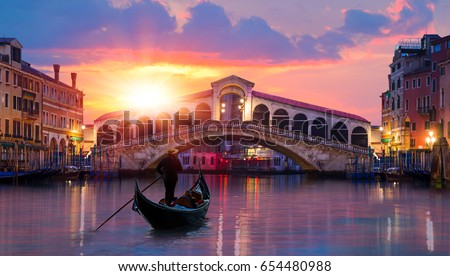 Gondola on Canal Grande in front of Rialto Bridge at dusk - Venice, Italy