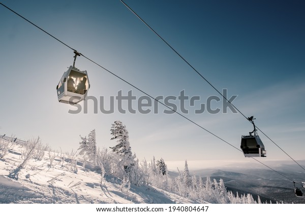 gondola ski lift in mountain ski resort, winter\
day, snowy spruce\
forest
