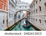 Gondolas floating on canal towards Bridge of Sighs (Ponte dei Sospiri). Venice, Italy