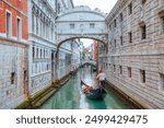 Gondolas floating on canal towards Bridge of Sighs (Ponte dei Sospiri). Venice, Italy