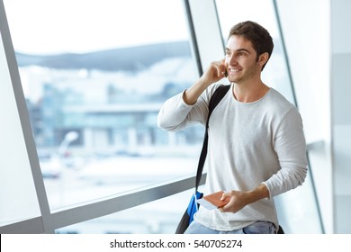 Gonna Be Home Soon! Portrait Of A Handsome Young Man Laughing Speaking On The Phone While Waiting For His Flight At The Airport Lounge