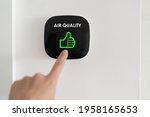 Good air quality indoor smart home domotic touchscreen system. air. Woman touching touchscreen checking air purifier filter at green level with thumbs up graphics.