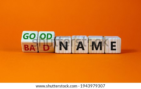 Good or bad name symbol. Turned wooden cubes and changed words 'bad name' to 'good name'. Beautiful orange background, copy space. Business and good or bad name concept.