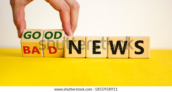 Good or bad news concept.\
Hand flips cubes and changes the words \'bad news\' to \'good news\'.\
Beautiful yellow table, white background. Business concept. Copy\
space.