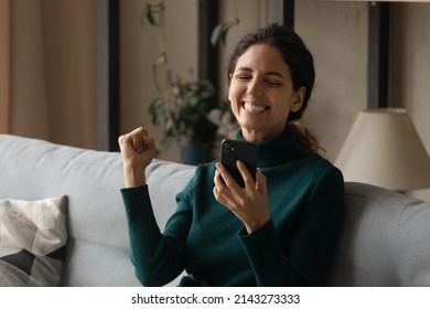 Good Bit Of Luck. Excited Cheering Young Hispanic Woman Raise Fist Up Reading Amazing Job Sales Proposal From Cellphone Screen. Happy Euphoric Millennial Lady Get Bank Email With Loan Credit Approval