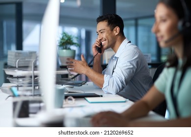 Good business is based on good communication. Shot of a young man answering the phone while working in a modern call centre. - Shutterstock ID 2120269652