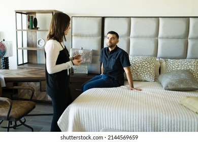 Good Deal. Female Sales Representative Speaking With A Client Looking To Buy New Furniture Bedroom