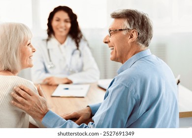 Good Diagnosis. Happy elderly couple looking at each other during consultation with female doctor at clinic, free space - Powered by Shutterstock