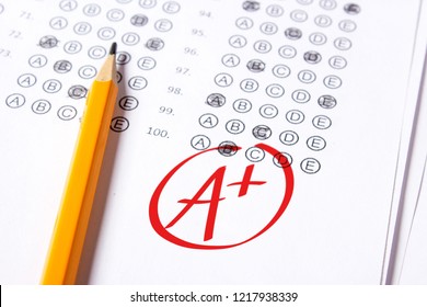 Good grade of A plus (A+) is written with  red pen on the tests. - Shutterstock ID 1217938339