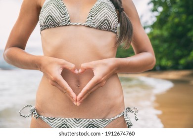 Good Gut Health Woman Doing Love Heart Shape With Hands On Healthy Belly. Bikini Woman Vacation Travel Concept For Probiotics, IBS, Stomach Bug Pain, Cramps.