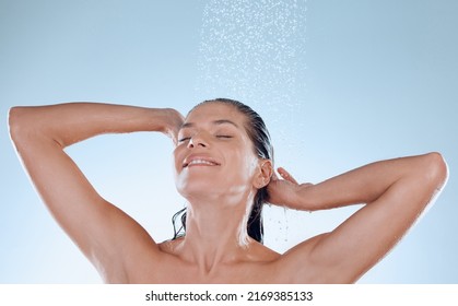 A Good Hair Day Is Coming. Studio Shot Of A Young Woman Taking A Shower Against A Blue Background.