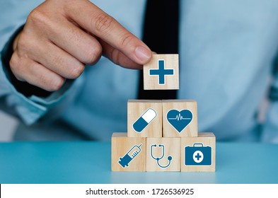 Good Healthcare And Insurance Concept.Business Hand Choose Plus Sign On Wood Cube Block,Positive Quantity,Take Care And Safety.