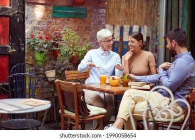 good, healthy conversation between elderly woman and young adult couple. breakfast in outdoor cafe - Powered by Shutterstock