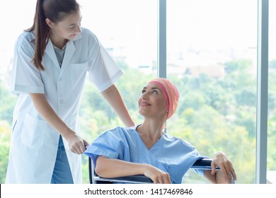 Good Hospital Provide Quality Medical Service. Professional Nurse Take Care A Patient.  Senior Caucasian Woman Cover Head With A Cloth Caused Of Chemotherapy Cancer, Smiling And Sitting On Wheelchair.