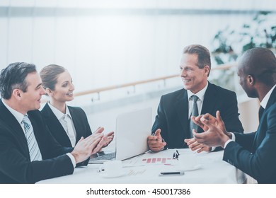 Good Job! Business People In Formalwear Sitting Together At The Table And Applauding