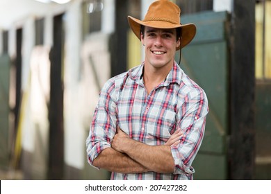 good looking cowboy with arms crossed in stable