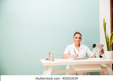 Good Looking Female Masseuse Sitting At A Front Desk And Greeting Customers With A Smile At A Health And Beauty Spa