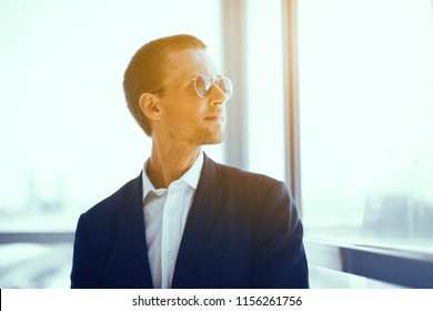 Good Looking Guy In Sunglasses. Young Stylish Confident Businessman Wearing Jacket And White Collar Shirt Looking Into Distance.